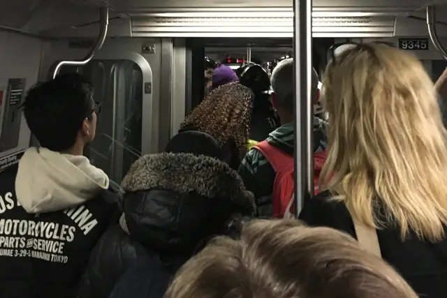 Straphangers evacuate a Manhattan-bound E train on Christmas night